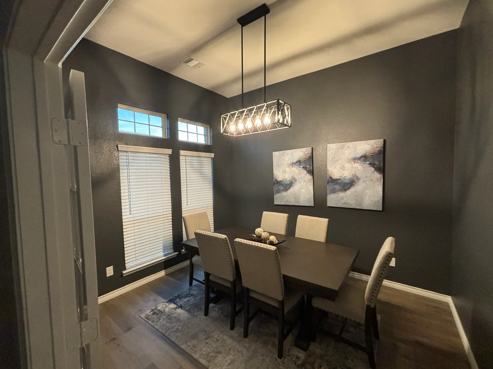 Charcoal gray painted dining room walls with white ceiling, trim, and transom windows