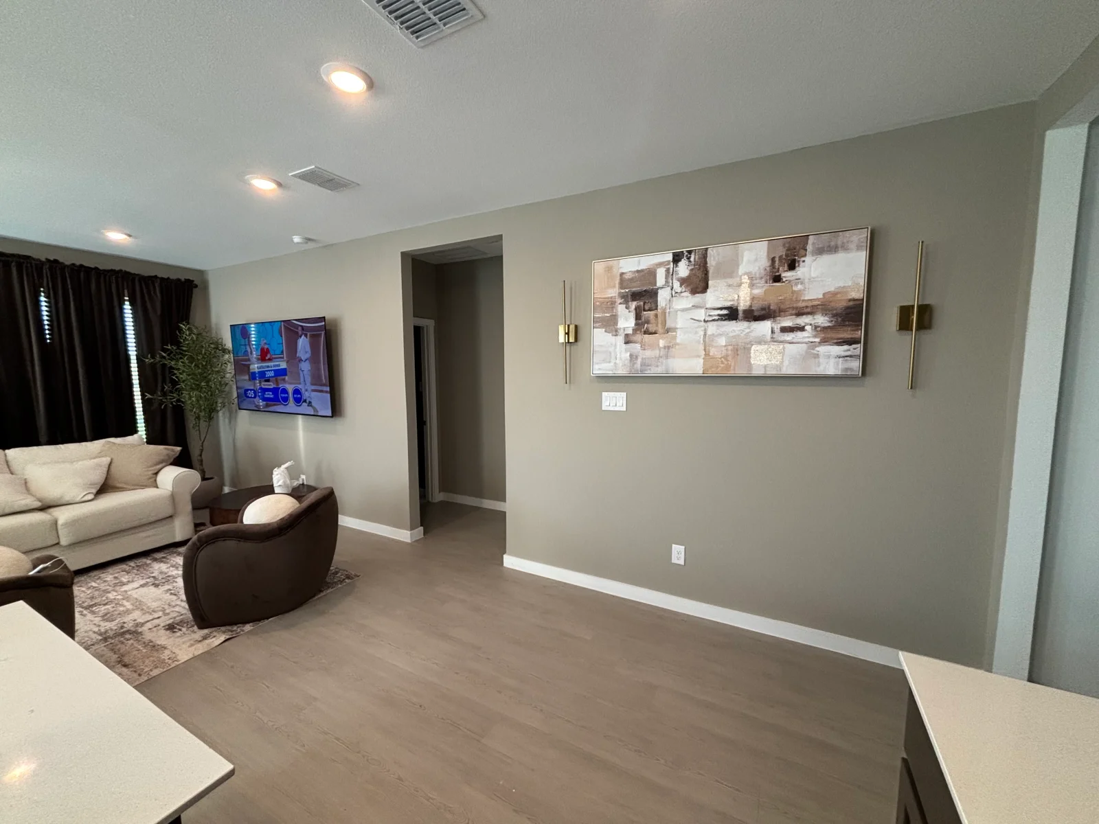 Taupe walls with white trim, recessed ceiling lights, and neutral interior paint finish
