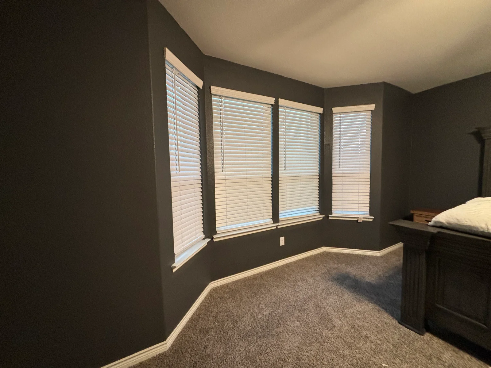 Dark charcoal painted bedroom walls with white trim, ceiling, and window frames